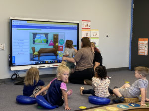 Students sitting around a SmartTV practicing skills